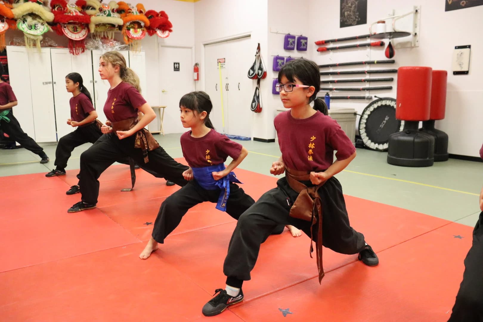 Young students practising low lunging stances with an instructor
