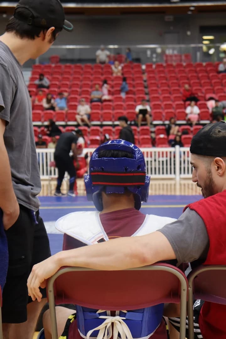 A young Sanda competitor in headgear waiting at the arena
